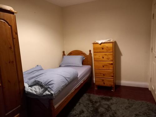 um pequeno quarto com uma cama e uma cómoda em Hall 1 em Farnley