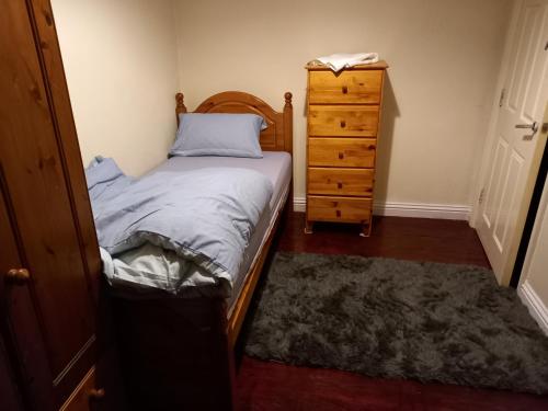 a small bedroom with a bed and a dresser at Hall 1 in Farnley