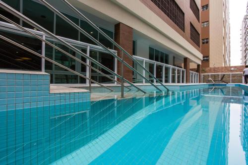 a swimming pool in front of a building at Estanconfor Santos com Vista Mar 7 AC Garagem alto 17º andar in Santos