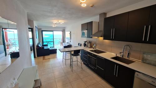 uma cozinha com um lavatório e uma bancada em DELUXE 3 Rooms74m2,TRANSFE-R inc! SEAVIEW on AMADORES,2 heatPOOLs, PARKING, 600 MB,Dishwasher,2Lift,,3 BEACHes em Playa del Cura