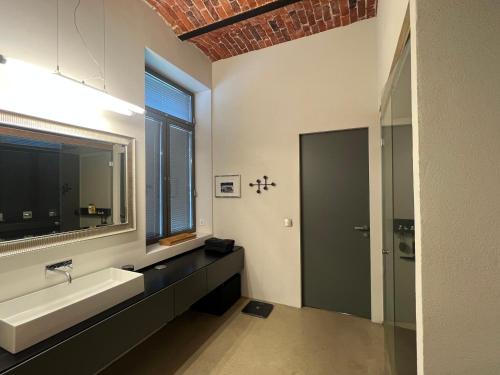a bathroom with a sink and a mirror and a window at Loft Suite in Lappeenranta
