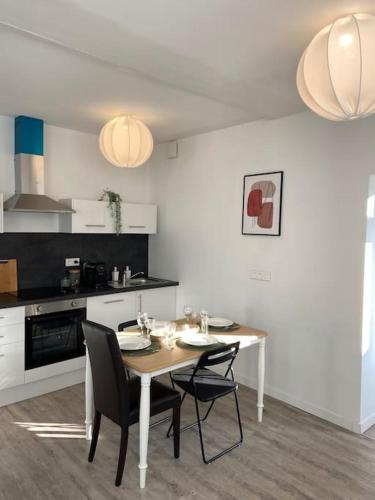 une cuisine avec une table et des chaises dans une pièce dans l'établissement L’Adorable Gayant, à Waziers