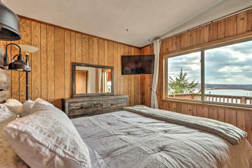 a bedroom with a bed and a large window at Lakeside Home with Deck Near Hunting and Fishing in Galmey