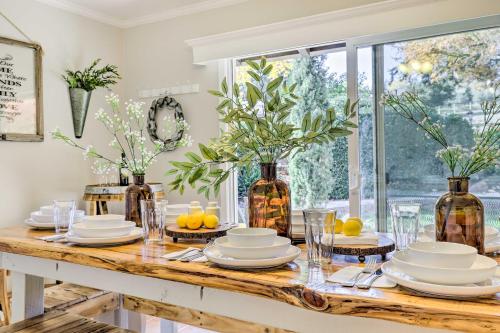 a dining room table with plates and vases on it at Modern Home in Napa Area with Hot Tub and Game Room! in Petaluma
