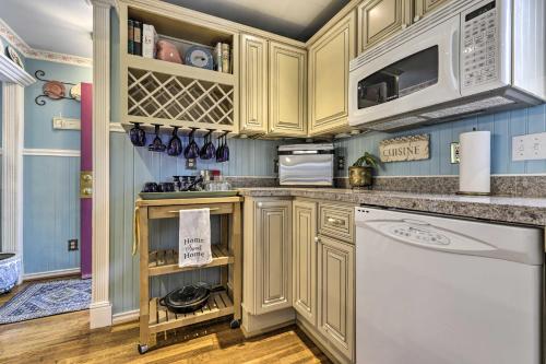 a kitchen with wooden cabinets and a white dishwasher at Lakefront Home, Close to Mt Southington! in Wolcott