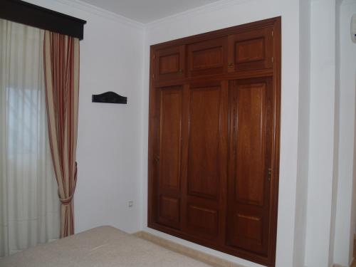 a wooden door in a room with a bed at Caico's in Prado del Rey