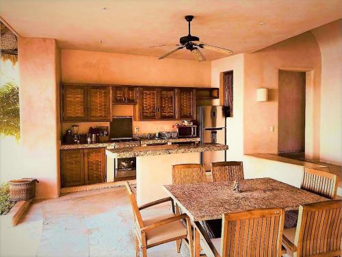 a kitchen with a table and chairs and a counter at Villa Peninsula in Zihuatanejo