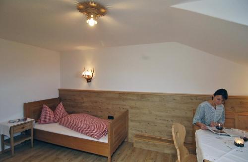 a woman sitting at a table in a room at Gästehaus Alte Bergmühle in Fischbachau