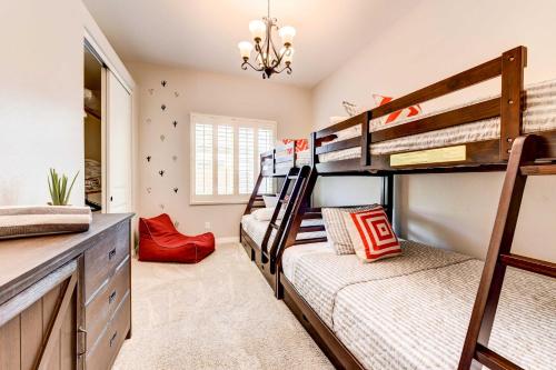 a bedroom with two bunk beds and a chandelier at Pool, BBQ and Bar Family Home in Queen Creek in Queen Creek