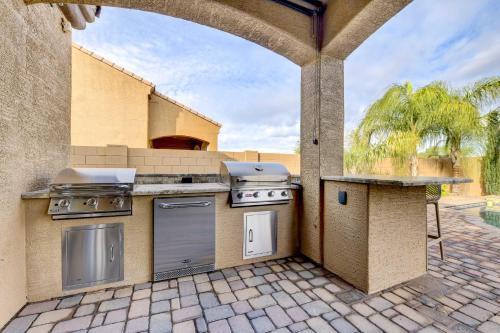 an outdoor kitchen with a grill and a table at Pool, BBQ and Bar Family Home in Queen Creek in Queen Creek
