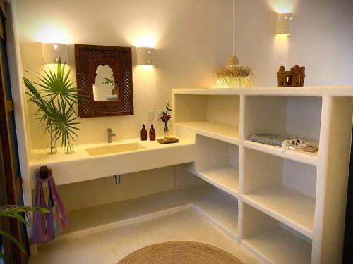 a bathroom with a sink and a mirror at Casa Las Gatas in Zihuatanejo