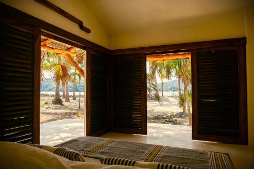 a bedroom with a bed and a view of the beach at Casa Las Gatas in Zihuatanejo