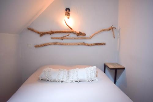 a bedroom with a bed with a branch on the wall at Appartement classé "La Tour" in Dole