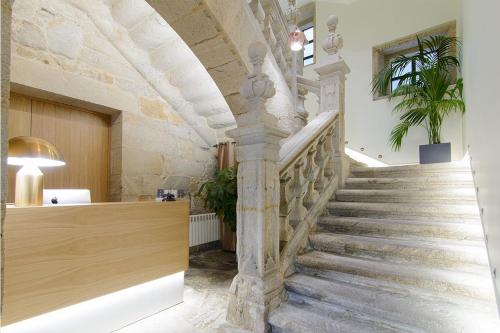 a staircase in a building with a stone wall at Pazo de Mendoza in Baiona