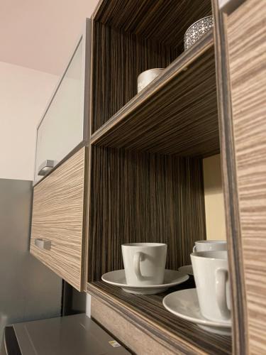 a cabinet with two cups and plates in it at Peaceful living, 4 minutes from the city center in Košice