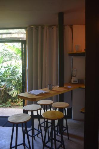 a table and stools in a room with a counter at OutBox Inn in Monteverde Costa Rica
