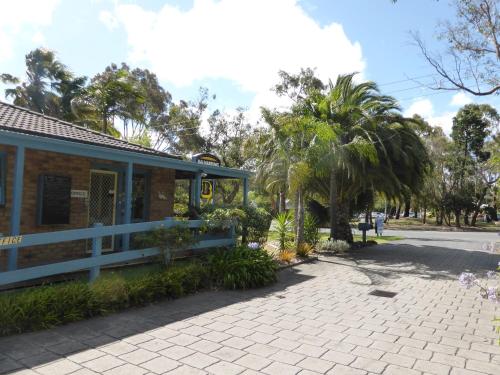 a building with a sidewalk next to a street at The Balnarring Motel in Balnarring
