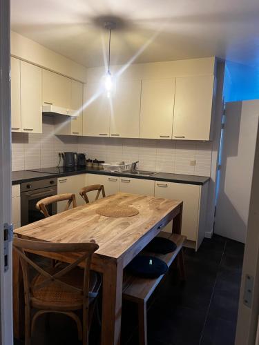 eine Küche mit einem Holztisch und Stühlen in der Unterkunft Apartment 202 in Gent