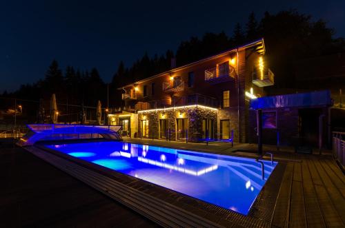 a swimming pool in front of a house at night at Hotel Jirinka in Dolní Morava