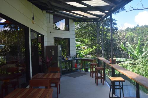 a bar with wooden tables and chairs on a patio at OutBox Inn in Monteverde Costa Rica