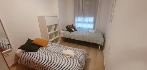 Habitación pequeña con 2 camas y ventana en Gran piso cerca Centro Comercial y Playa, en Ceuta