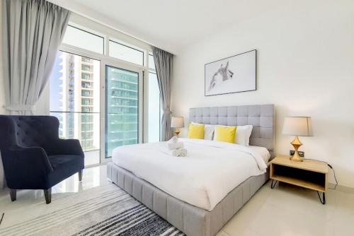 Un dormitorio con una cama grande y una silla. en Sunrise Bay 2 - Chic Two Bedroom, en Dubái