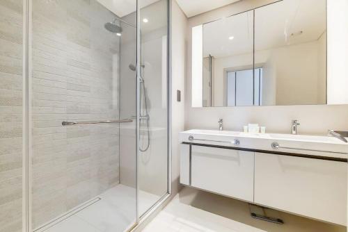 Un baño con ducha, lavabo y espejo. en Sunrise Bay 2 - Chic Two Bedroom, en Dubái