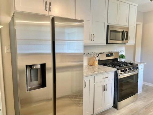 uma cozinha com armários brancos e um frigorífico de aço inoxidável em Mary Lake Hideaway em Bryan