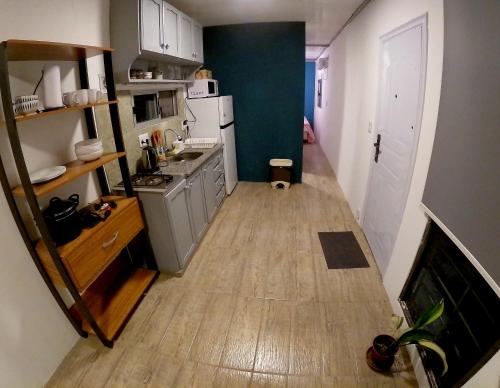 una piccola cucina con armadietti bianchi e pavimenti in legno di Winterfell Casa ideal para parejas. a Ocean Park