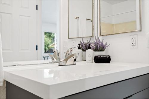 uma casa de banho branca com um lavatório e um espelho em @ Marbella Lane - Modern 4BR Home in Oro Valley em Oro Valley