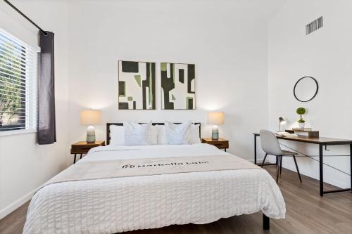 a white bedroom with a large bed and a desk at @ Marbella Lane - Modern 4BR Home in Oro Valley in Oro Valley