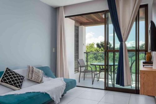 a living room with a blue couch and a table at Residence in Barra de São Miguel
