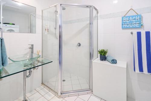 a shower with a glass door in a bathroom at Coastal retreat, private, wine, netflix in Buddina