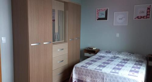 een slaapkamer met een bed en een dressoir bij Residencial Recanto Paraíso BC - Cobertura in Balneário Camboriú