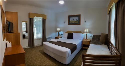 a hotel room with a bedroom with a bed and a desk at Riverview at Ross in Ross