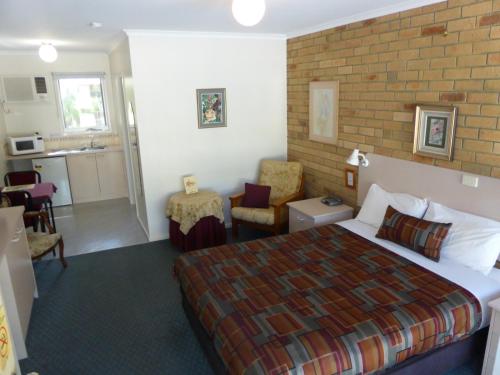 a hotel room with a bed and a kitchen at The Balnarring Motel in Balnarring