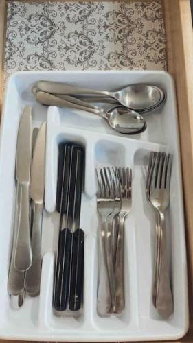 a tray of silver utensils on a table at Renovated Bungalow Getaway in Philomath