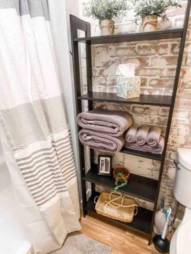 a bathroom with a shelf with towels and a toilet at Renovated Bungalow Getaway in Philomath