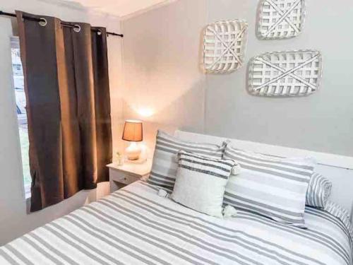 a bedroom with a large bed with striped pillows at Renovated Bungalow Getaway in Philomath