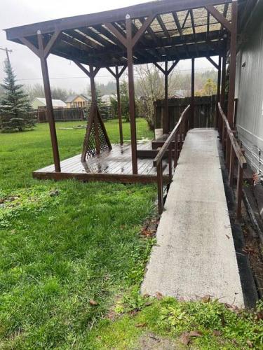 a wooden boardwalk leading to a pavilion in a yard at Renovated Bungalow Getaway in Philomath