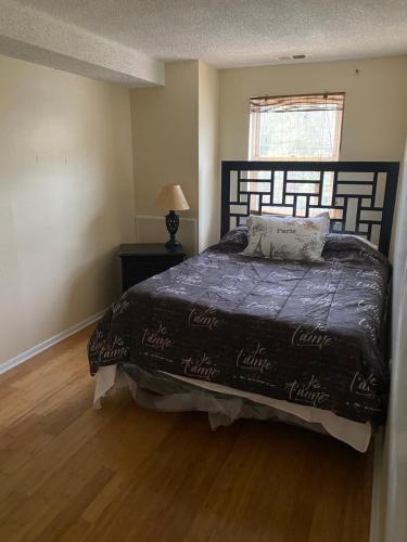 a bedroom with a bed with a black comforter and a window at Island Avenue in Philadelphia