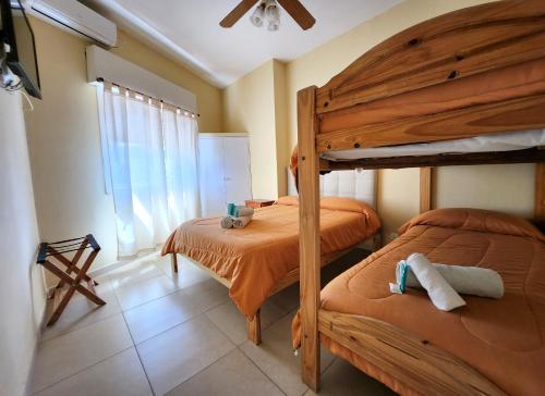 a bedroom with two bunk beds and a window at Hotel Los Ángeles in San Clemente del Tuyú