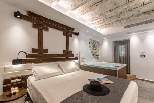 1 dormitorio con 1 cama grande y bañera en Mariet Naxos Spa & Suites en Naxos