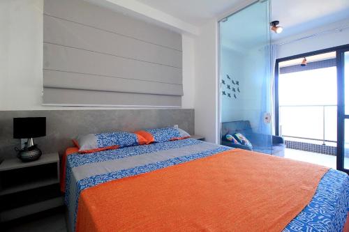 1 dormitorio con 1 cama grande con manta naranja en Vista Panorâmica, Conforto e Piscina à Beira-Mar, en Salvador