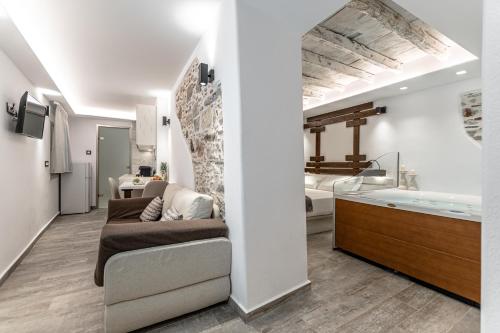 a living room with a couch and a bath tub at Mariet Naxos Spa & Suites in Naxos Chora