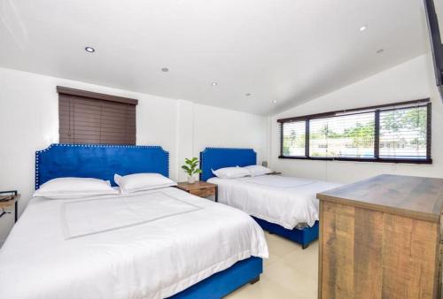 Dos camas en una habitación con dos ventanas. en Five Bedroom Villa With POOL In Highland Lakes Near Aventura Mall, en Miami
