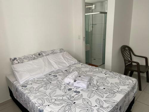 una camera da letto con un letto e un asciugamano sopra di Apart. Dois quartos na Ponta Verde a Maceió
