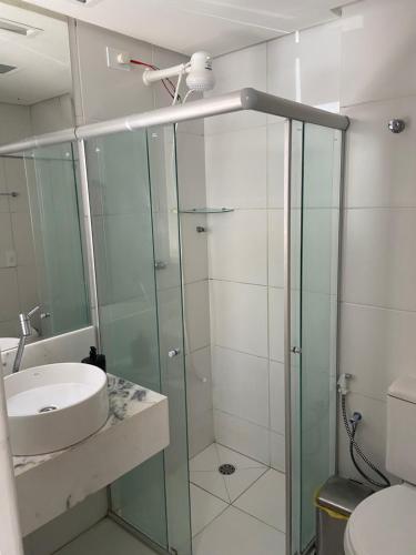een badkamer met een glazen douche en een wastafel bij Apart. Dois quartos na Ponta Verde in Maceió