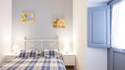 a bedroom with a bed with plaid sheets and two lamps at Apartamento Lorenzana in Toledo
