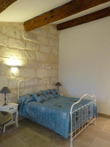a bedroom with a bed and a stone wall at Le Mas d'Isnard in Arles